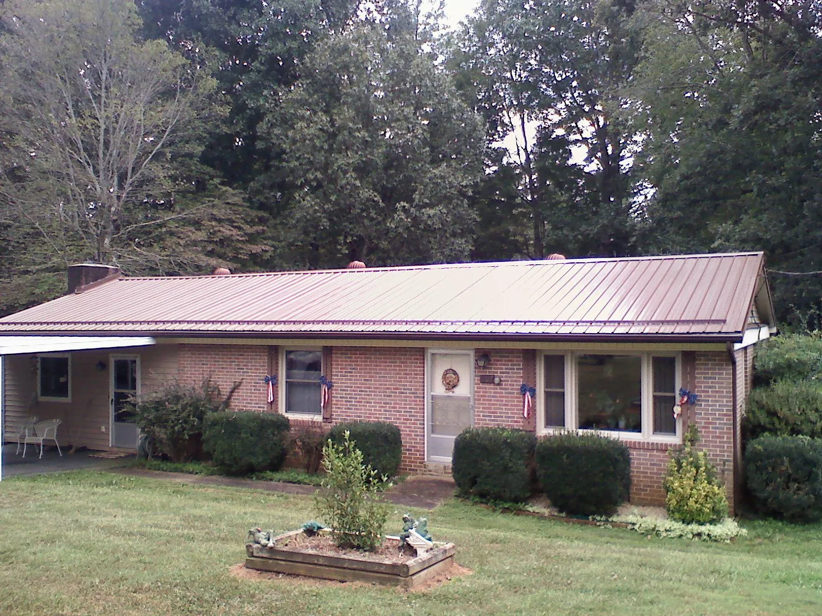 Bronze metal roof on a brick ranch home with a carport in Hillsdale